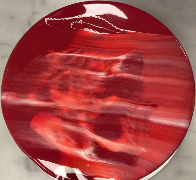 Top-down view of the same mirror-glaze Fraisier — the marbled red glaze poured to a flawless, glassy surface.